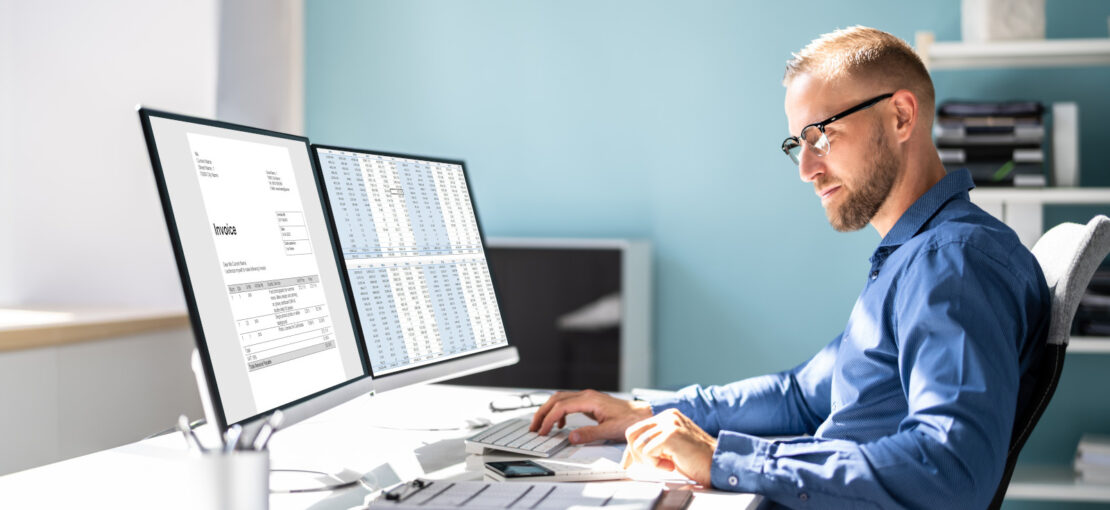 Metier Informaticien - Commercial faisant des calculs devant des ecrans d'ordinateur - numerique